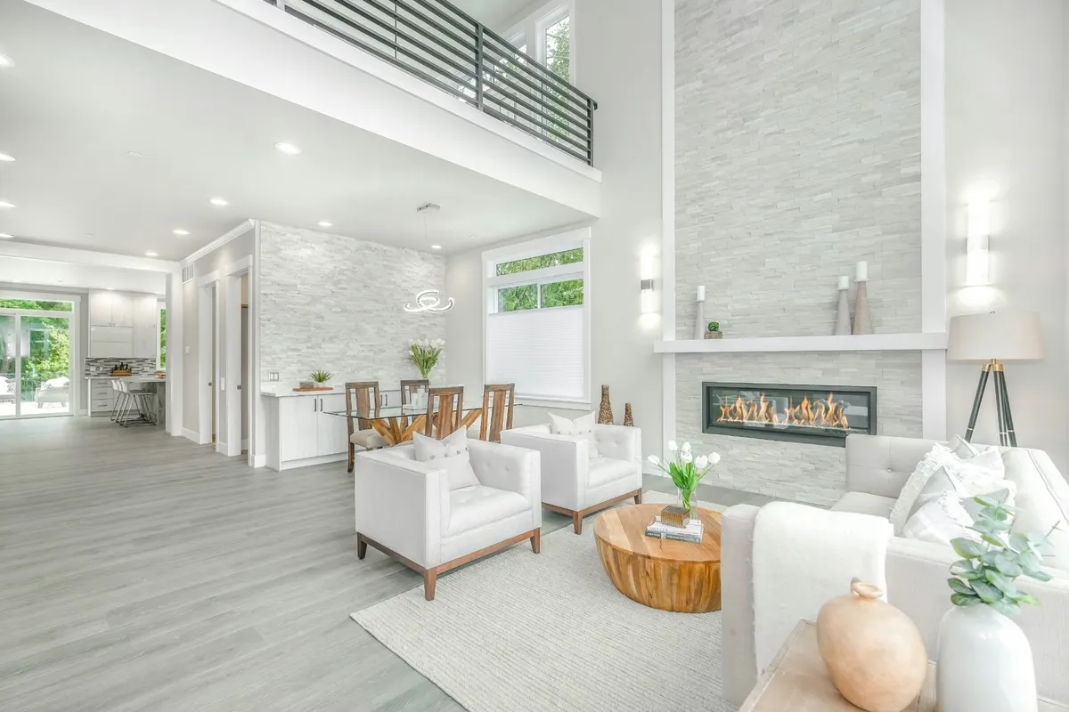 Bright open-plan living and dining space with a linear fireplace, styled for a property listing