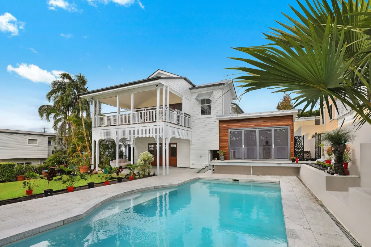 Exterior property photograph with pool, garden and clear sky ready for editing